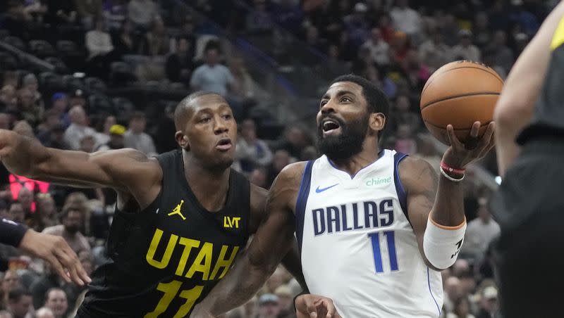 Dallas Mavericks guard Kyrie Irving (11) drives as Utah Jazz guard Kris Dunn (11) defends during an NBA basketball game on Jan. 1, 2024, in Salt Lake City.