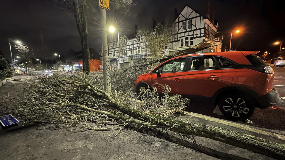 Una rama caída se ve sobre un auto en la calle Lisburn de Belfast, en el Irlanda del Norte, al paso de la tormenta Isha el domingo 21 de junio de 2024. (Liam McBurney/PA via AP)