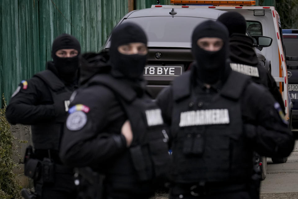 Romanian gendarmes are backdropped by a UK registered luxury vehicle which was seized in a case against media influencer Andrew Tate, is towed away, on the outskirts of Bucharest, Romania, Saturday, Jan. 14, 2023. Prosecutors seized several luxury vehicles after Tate lost a second appeal this week at a Bucharest court, where he challenged the seizure of assets in the late December raids, including properties, land, and a fleet of luxury cars. More than 10 properties and land owned by companies registered to the Tate brothers have also been seized so far. (AP Photo/Vadim Ghirda)