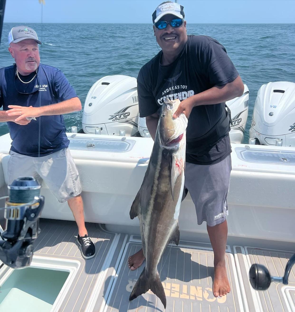 Capt. Freddy Gamboa of Andreas Toy Charters holds up a 45-pound cobia. The fish was reeled in by Darren Guarino, standing to his left.