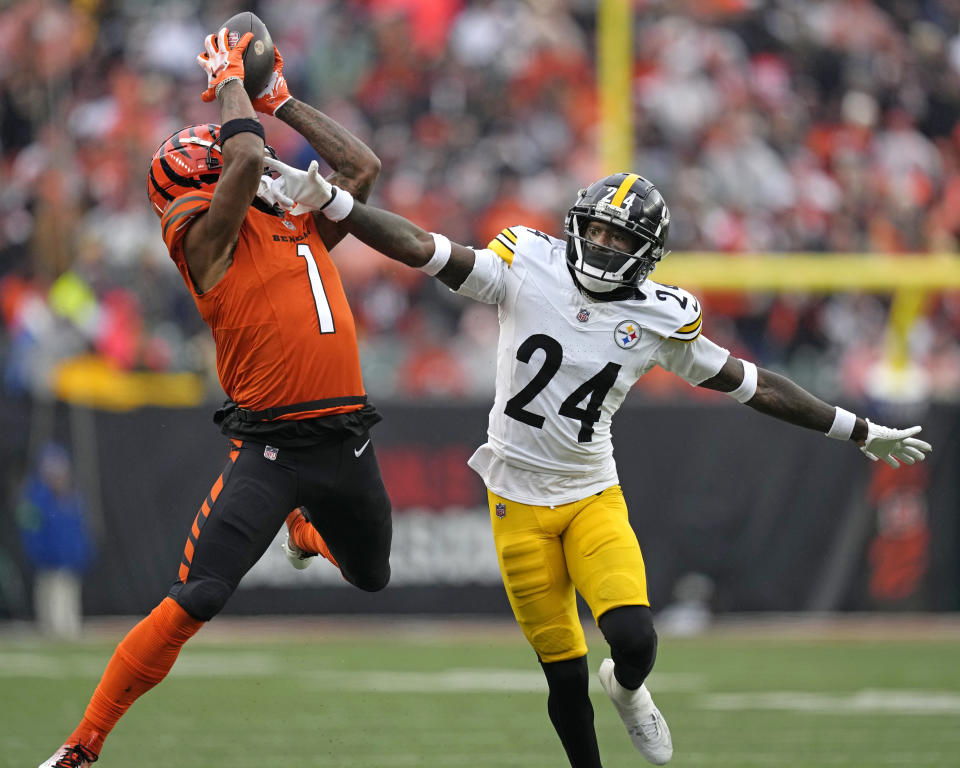 Cincinnati Bengals wide receiver Ja'Marr Chase (1) catches a pass from quarterback Jake Browning for a first down with Pittsburgh Steelers cornerback Joey Porter Jr. (24) defending during the second half of an NFL football game in Cincinnati, Sunday, Nov. 26, 2023. (AP Photo/Carolyn Kaster)