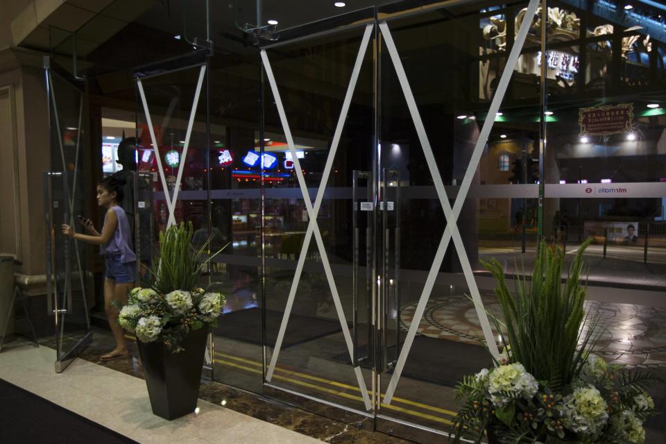 A girl walks into a shopping mall, which entrances are taped in anticipation of Typhoon Usagi, in Hong Kong