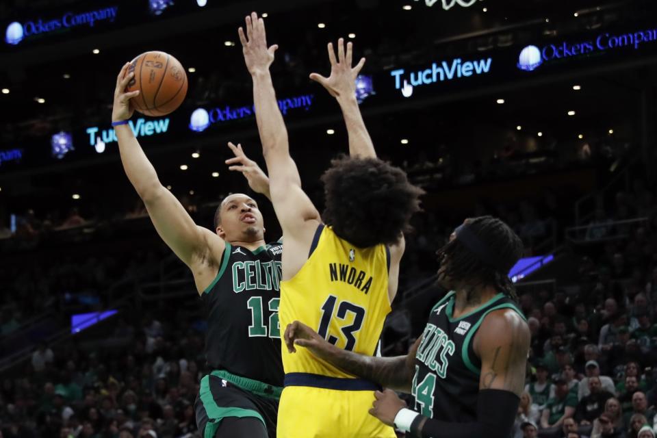 Boston Celtics' Grant Williams (12) shoots against Indiana Pacers' Jordan Nwora (13) during the first half of an NBA basketball game Friday, March 24, 2023, in Boston. (AP Photo/Michael Dwyer)