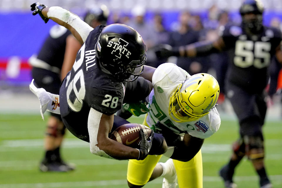 FILE - In this Jan. 2, 2021, file photo, Iowa State running back Breece Hall (28) is hit by Oregon safety Verone McKinley III during the first half of the Fiesta Bowl NCAA college football game in Glendale, Ariz. Who would make a college football Super League? Think big-brand schools with large fanbases and a history of success ... such as Oregon. (AP Photo/Ross D. Franklin, File)