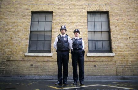 Police constables Ben Sinclair and Karen Spencer pose for a photograph wearing their Metropolitan Police beat uniforms, in London, October 9, 2014. REUTERS/Paul Hackett
