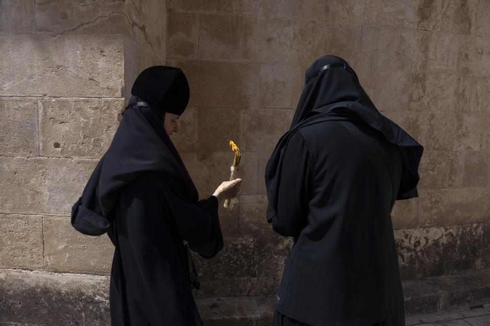 Greek Orthodox nuns hold candles as they gather during the ceremony of the Holy Fire at the Church of the Holy Sepulchre, where many Christians believe Jesus was crucified, buried and rose from the dead, in the Old City of Jerusalem, Saturday, May 4, 2024. (AP Photo/Ohad Zwigenberg)