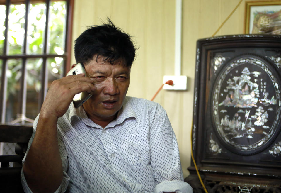 Doan Van Thanh, father of Doan Thi Huong, one of the two women accused of killing Kim Jong Nam, answers a phone call at his house in Nghia Binh village, Nam Dinh province, Vietnam, Thursday, Aug. 16, 2018. Two Southeast Asian women on trial for the brazen assassination of the North Korean leader's half brother were told to begin their defense Thursday, extending the trial for several more months. (AP Photo/ Hau Dinh)