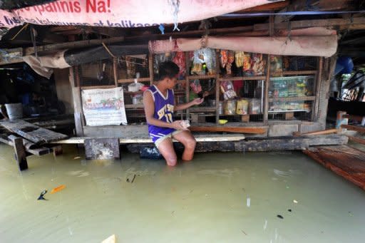 A boy is seen making a purchase at a flooded convinient store in Manila on August 15. Tropical Storm Kai-tak blew out of the Philippines on Thursday, offering some relief for millions of people struggling to recover from a brutal few weeks of monsoon rains that claimed 109 lives