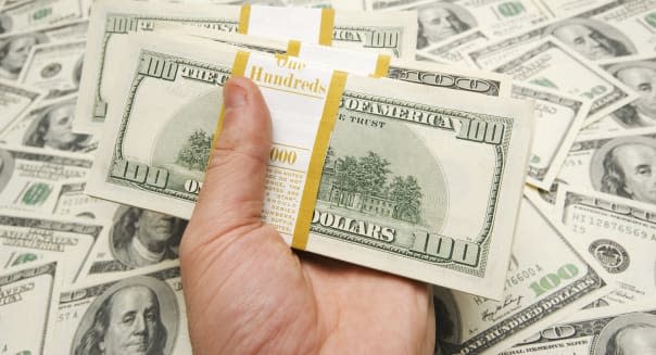 Hand holding american dollars against money background