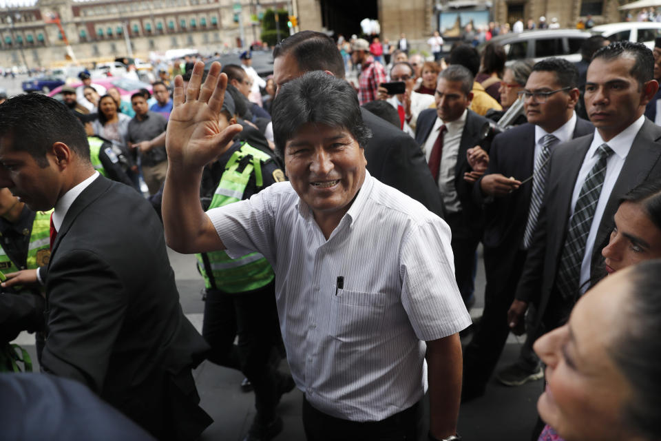 Bolivia's former President Evo Morales waves upon arrival to meet Claudia Sheinbaum, mayor of Mexico City, in Mexico City, Wednesday, Nov. 13, 2019. Mexico has granted asylum to Morales, who resigned on Nov. 10th under mounting pressure from the military and the public after his re-election victory triggered weeks of fraud allegations and deadly protests. (AP Photo/Marco Ugarte)