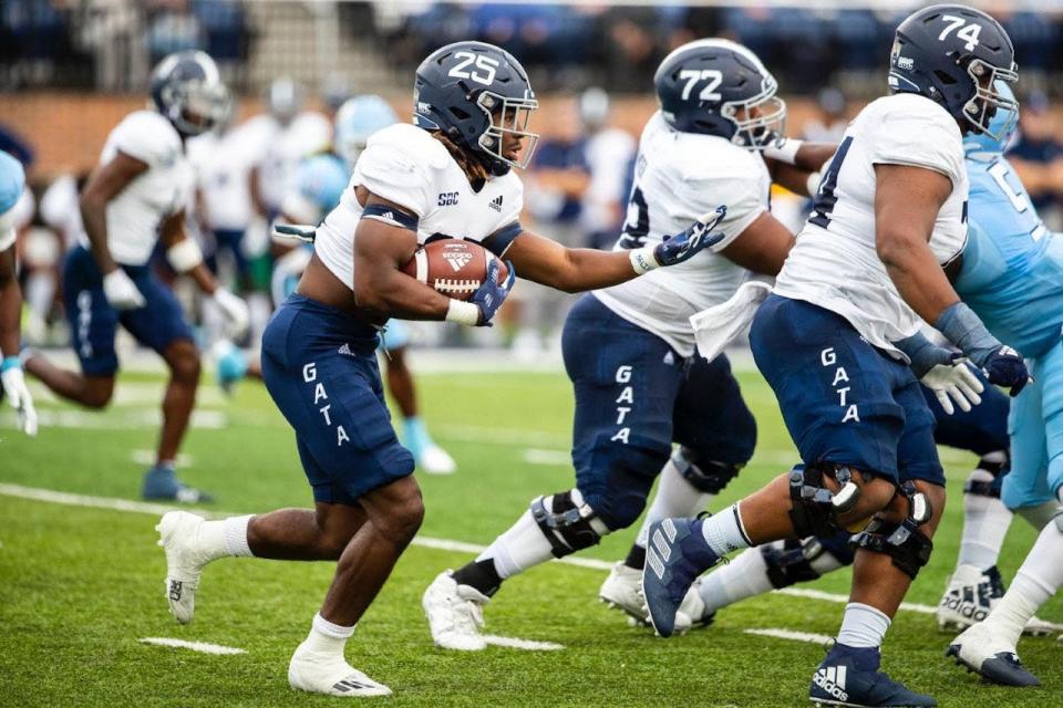 Georgia Southern running back Jalen White (25) follows his blockers Khalil Crower (72) and  Pichon Wimbley (74) against the Old Dominion defense on Saturday, Oct. 22, 2022 in Norfolk, Virginia. Georgia Southern won 28-23.