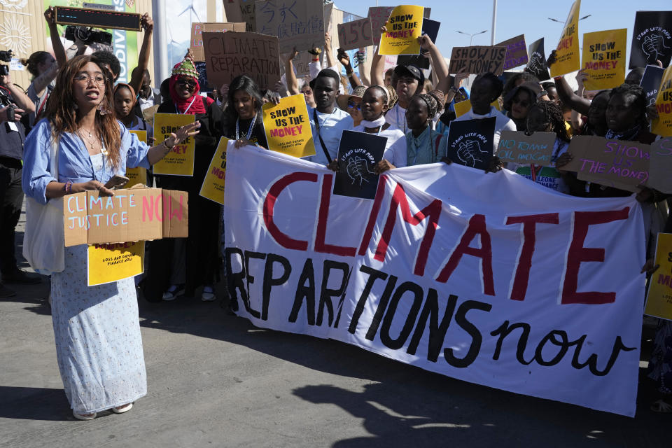 Mitzi Jonelle Tan, of the Philippines, left, speaks at a Fridays for Future protest calling for money for climate action at the COP27 U.N. Climate Summit, Friday, Nov. 11, 2022, in Sharm el-Sheikh, Egypt.