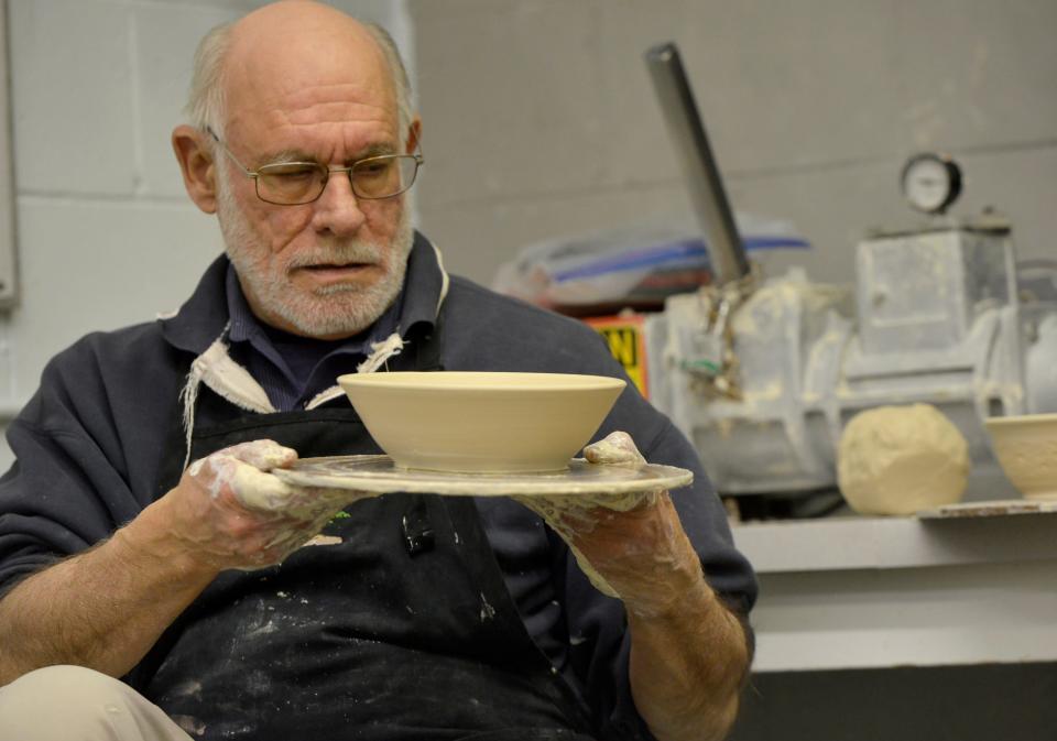 Andrew Arnault takes another look at his newly created bowl. Arnault and classmates have spent more than 350 hours since September making ceramic bowls for the Mangia al Museo! fundraiser.