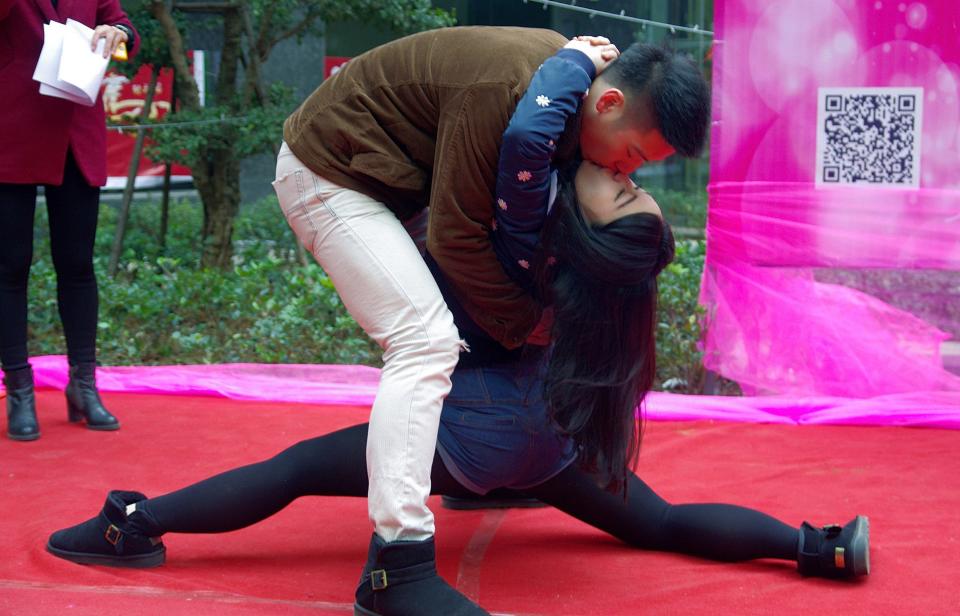 A couple participates in a kissing competition to celebrate Christmas in Wuhan, Hubei province December 24, 2013. The competition required the attendants to kiss in different postures for a prize worth 15,000 Yuan ($2,470), local media reported. Picture taken December 24, 2013. REUTERS/Stringer (CHINA - Tags: SOCIETY TPX IMAGES OF THE DAY) CHINA OUT. NO COMMERCIAL OR EDITORIAL SALES IN CHINA