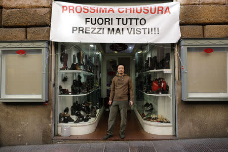 Renato Gu, 31, poses for a portrait under a banner outside his women's shoe and accessory shop in Rome November 21, 2014. REUTERS/Tony Gentile