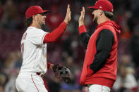 Cincinnati Reds' Kyle Farmer, left, celebrates with Graham Ashcraft after their baseball game against the Chicago Cubs, Monday, Oct. 3, 2022, in Cincinnati. (AP Photo/Jeff Dean)