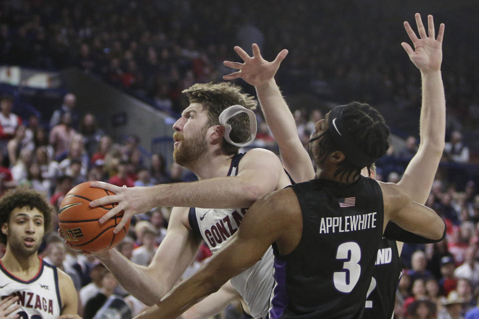 Gonzaga forward Drew Timme drives to the basket while defended by Portland forward Alden Applewhite (3) and guard Tyler Robertson during the first half of an NCAA college basketball game Saturday, Jan. 14, 2023, in Spokane, Wash. (AP Photo/Young Kwak)