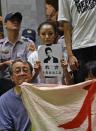 A protester displays a portrait of 20-year-old student Lin Kuan-hua, who police said killed himself in his New Taipei City home, during a demonstration at the entrance of the Education Ministry in Taipei on July 31, 2015