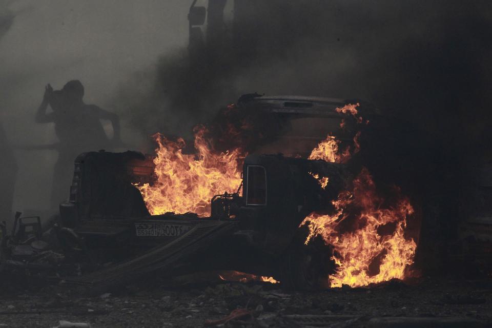 Residents extinguish a fire caused by what activists say was an air strike by forces loyal to Syria's President Assad on Tal Abyad street market in central Raqqa