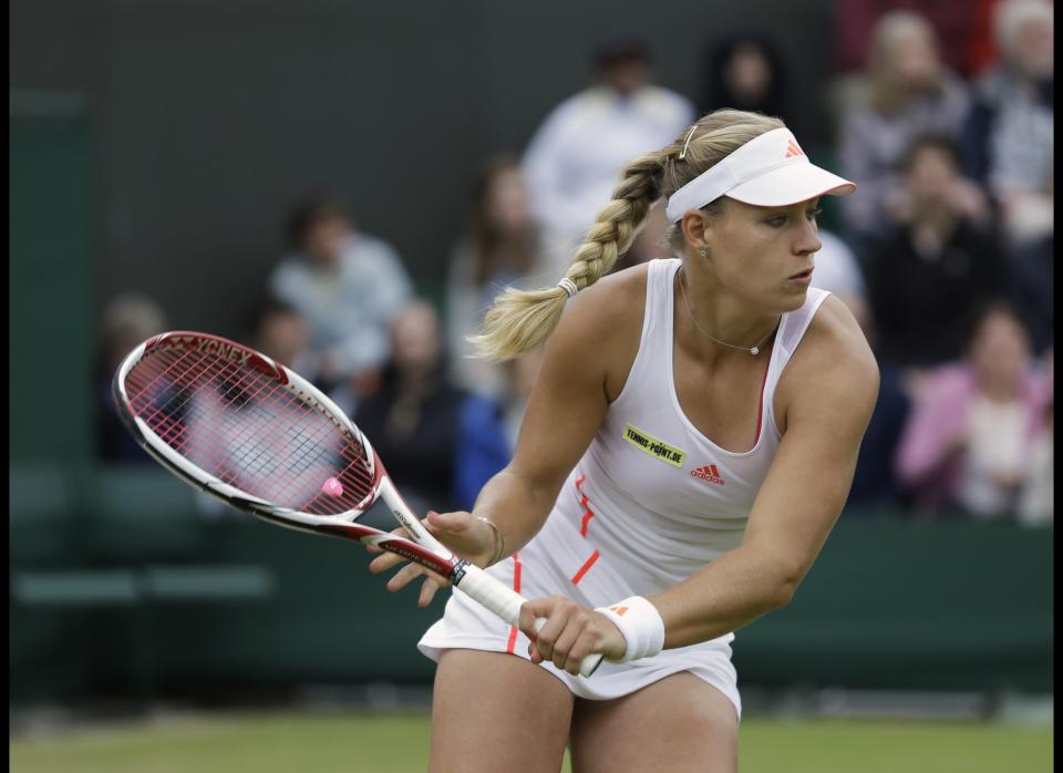 Angelique Kerber of Germany returns a shot against Kim Clijsters of Belgium during a fourth round singles match at the All England Lawn Tennis Championships at Wimbledon, England, Monday, July 2, 2012. 