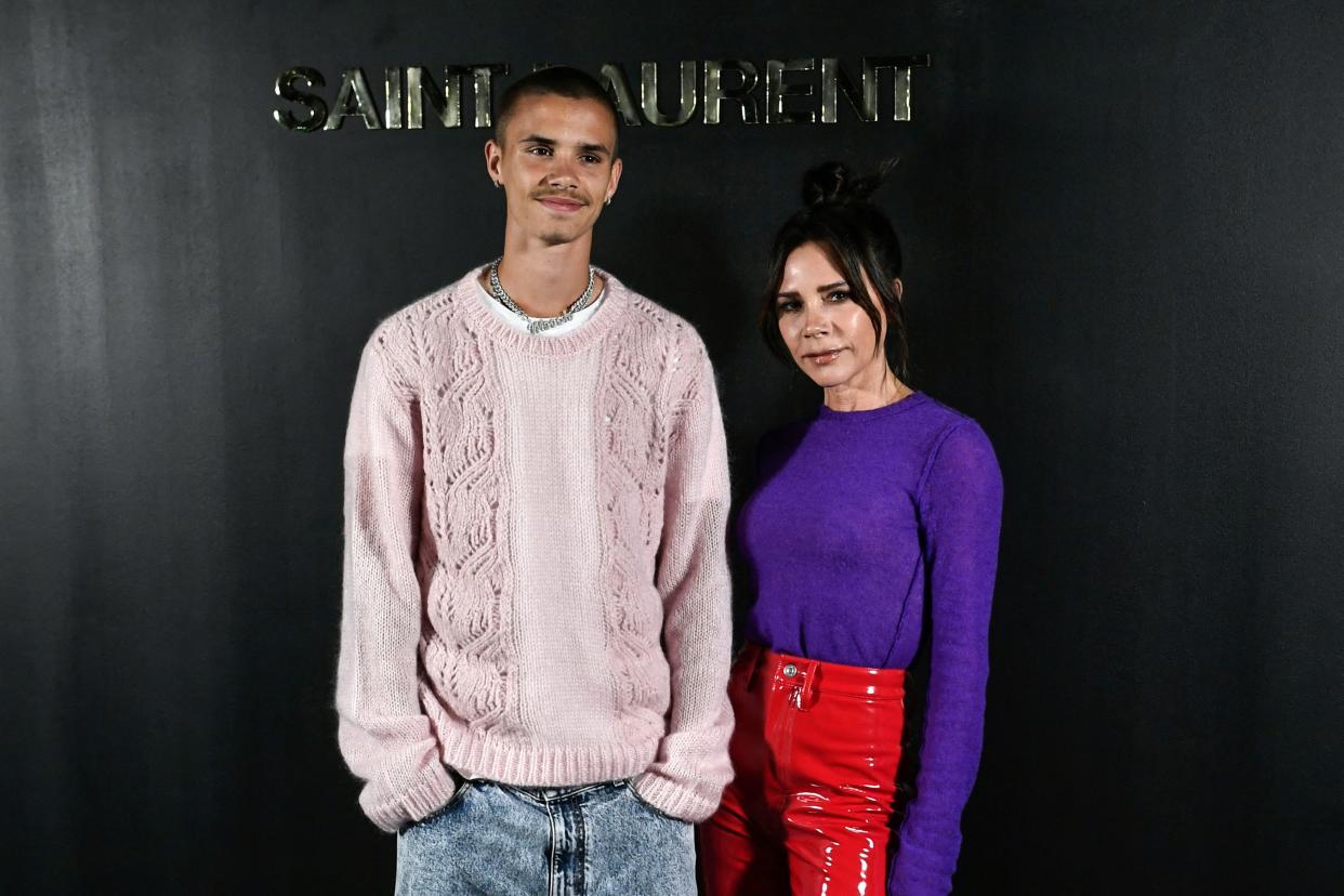 British singer and stylist Victoria Beckham (R) and her son soccer player and model Romeo Bekcham pose for a photocall prior the Saint-Laurent Fall-Winter 2022-2023 collection fashion show during the Paris Womenswear Fashion Week, in Paris, on March 1, 2022. (Photo by STEPHANE DE SAKUTIN / AFP) (Photo by STEPHANE DE SAKUTIN/AFP via Getty Images)