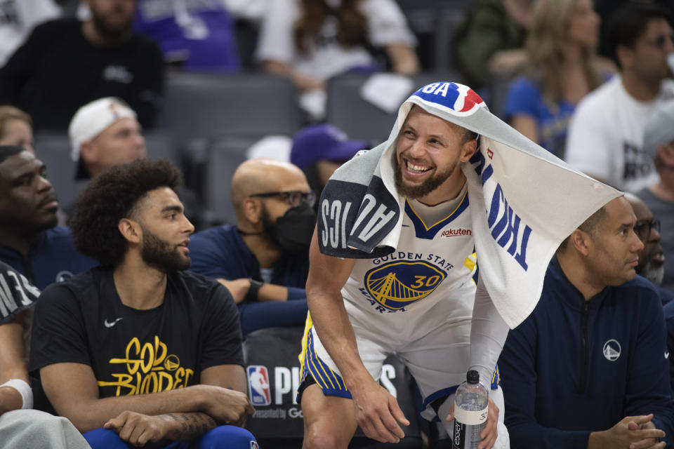 Golden State Warriors guard Stephen Curry (30) celebrates on the Warriors bench with Anthony Lamb by his side during the second half of Game 7 of an NBA basketball first-round playoff series against the Sacramento Kings on Sunday, April 30, 2023, in Sacramento, Calif. The Warriors won 120-100. (AP Photo/José Luis Villegas)