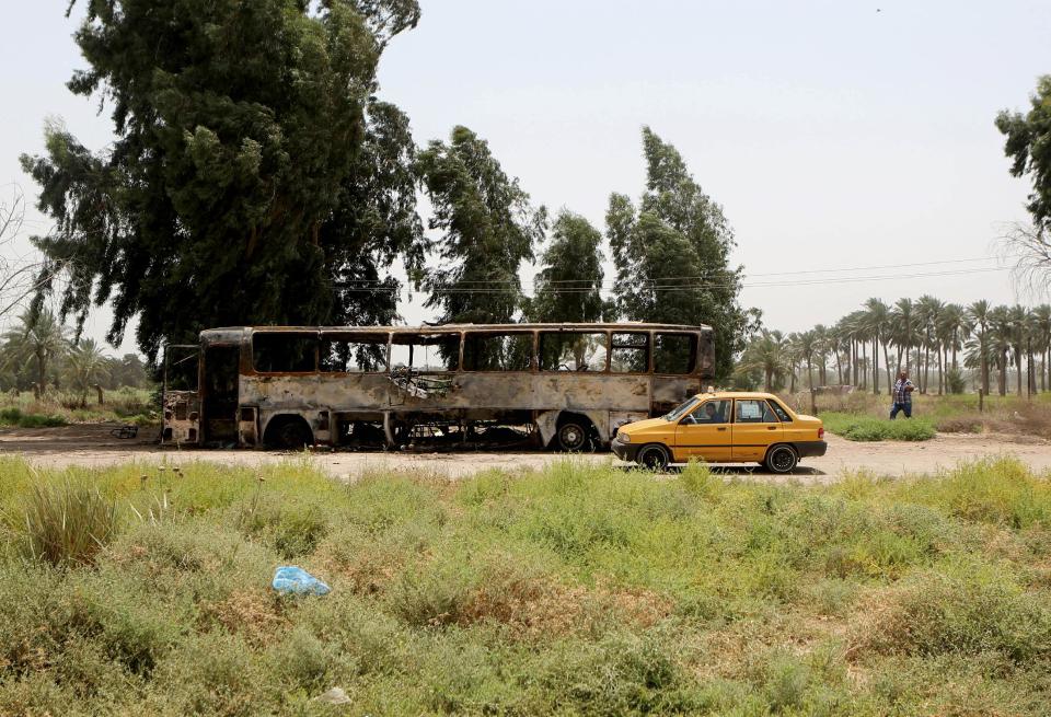 People inspect a destroyed prisoner transport bus in the town of Taji, about 12 miles (20 kilometers) north of Baghdad, Iraq, Thursday, July 24, 2014. Gunmen attacked a prisoner convoy north of Baghdad on Thursday, setting off a gunbattle with troops in which scores of prisoners and several soldiers were killed, brutally underscoring Iraq’s instability as lawmakers convened to elect a new president. (AP Photo/Khalid Mohammed)