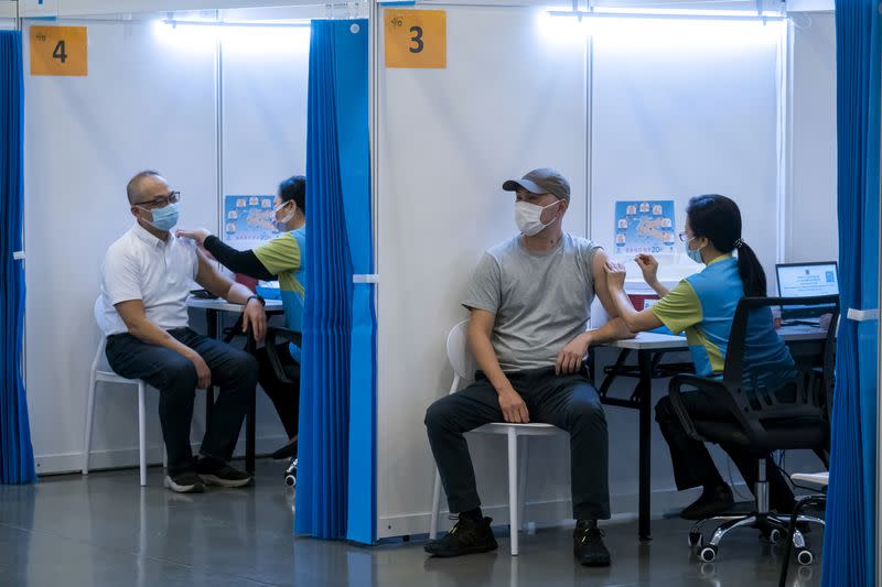 FILE PHOTO: People receive a dose of the Sinovac Biotech's COVID-19 vaccine at a community vaccination center in Hong Kong