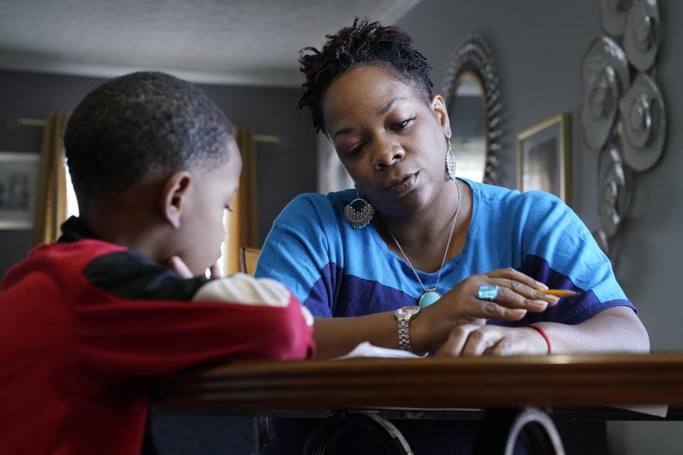 Tamela Ensrud helps her son, Christian, 7, with his homework at their home Monday, Nov. 21, 2022, in Nashville, Tenn. As parents try to help their children recover from several years of interrupted learning, some are struggling to get clear information explaining how their children are performing or a school plan to help them catch up on the learning they missed. (AP Photo/Mark Humphrey)