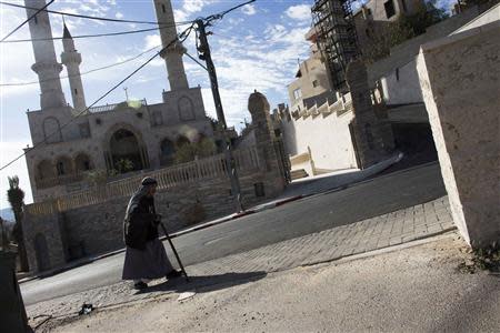 A man walks past a new mosque in the Israeli Arab village of Abu Ghosh, near Jerusalem November 22, 2013. REUTERS/Ronen Zvulun