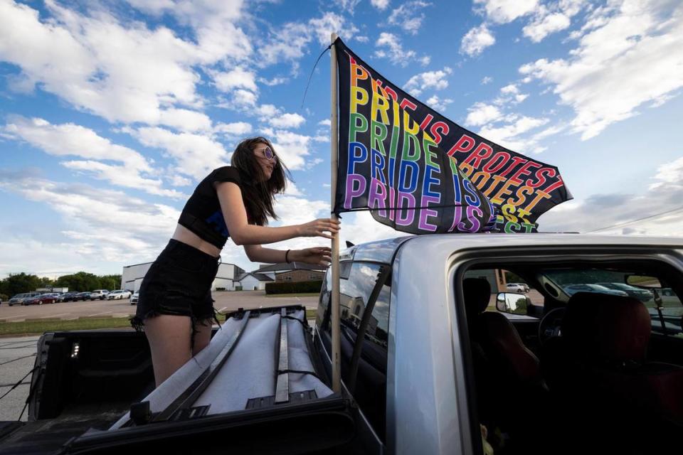 Hillary Ward puts up a Pride flag while protesting near Stedfast Baptist Church where a pastor preaches against homosexuality Wednesday, June 1, 2022, in Watauga.