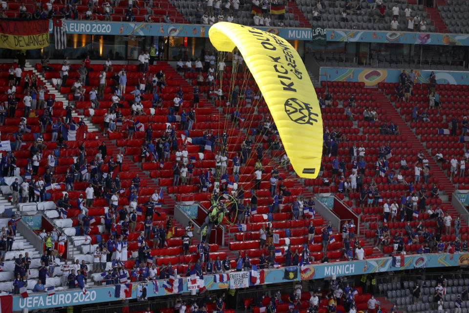 A Greenpeace paraglider lands in the stadium prior to the Euro 2020 soccer championship group F match between France and Germany at the Allianz Arena stadium in Munich, Tuesday, June 15, 2021. (AP Photo/ctivist Alexander Hassenstein, Pool)