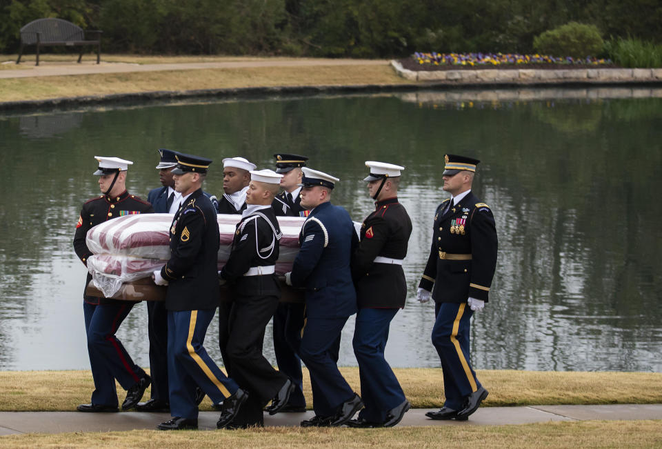 Rodeado con la bandera de Estados Unidos, el féretro con los restos del expresidente George H.W. Bush es cargado hacia su tumba cerca de la biblioteca presidencial el jueves 6 de diciembre de 2018 en College Station, Texas. (Smiley N. Pool/The Dallas Morning News via AP, Pool)