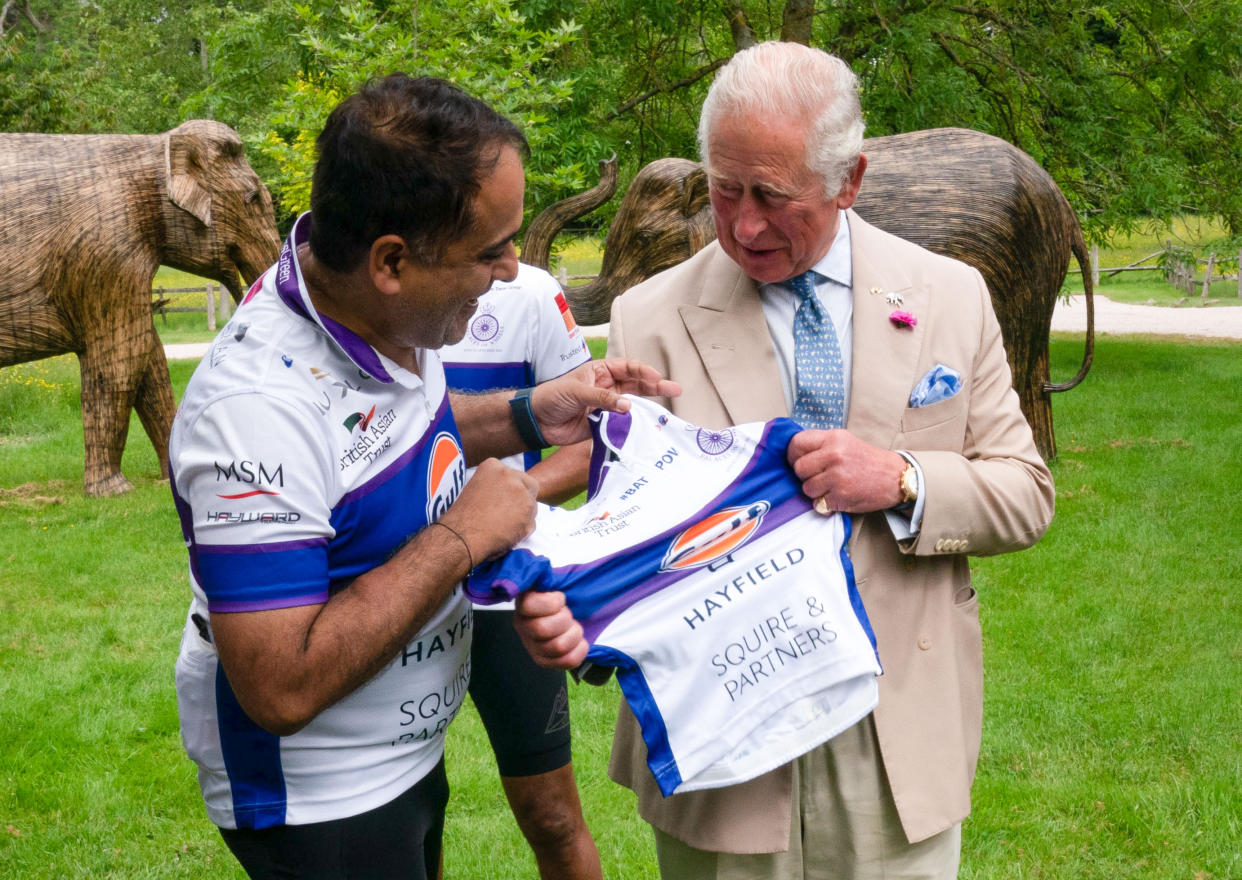 Rohit Chadda presents the Prince of Wales with a cycling vest, which was two sizes too small, before he joined representatives of the British Asian Trust at Highgrove in Gloucestershire before they embark on the charity's 'Palaces on Wheels' cycling event. Picture date: Thursday June 10, 2021.