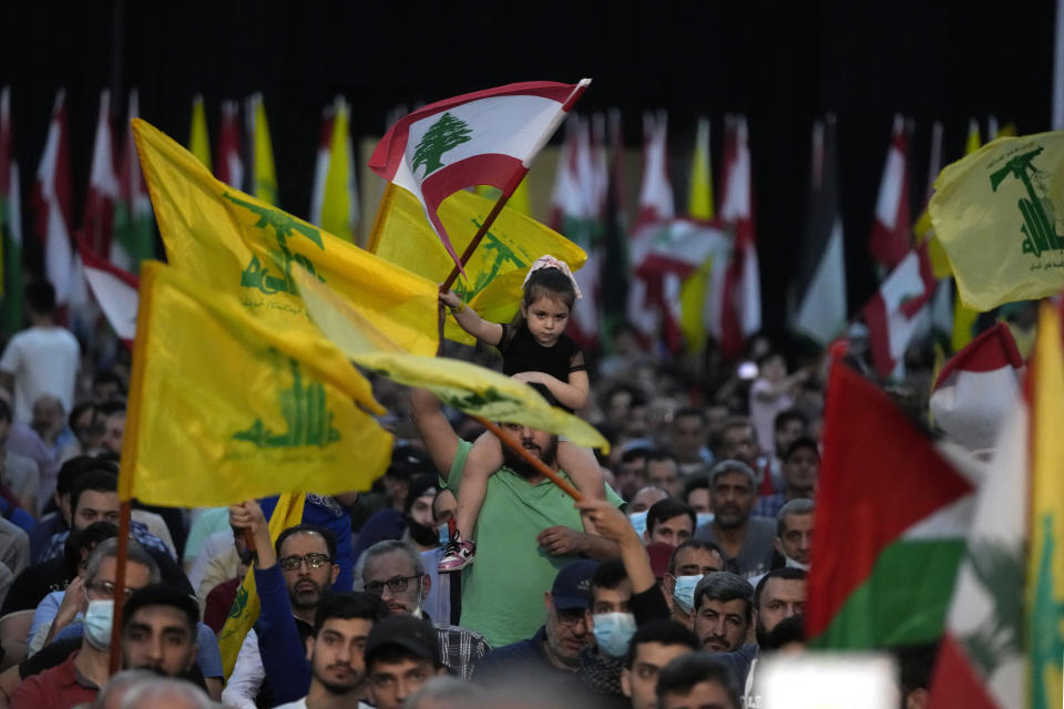 Hezbollah supporters wave flags, during a rally to mark Jerusalem day or Al-Quds day, in a southern suburb of Beirut, Lebanon, Friday, April 29, 2022. The leader of Lebanon's militant Hezbollah group warned Friday that if Israel continues to target Iran's presence in the region, Tehran could eventually retaliate by striking deep inside Israel. (AP Photo/Hassan Ammar)