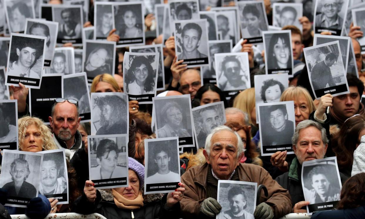 <span>People hold up portraits of victims of the 1994 bombing of the Argentinian Israeli Mutual Association, in Buenos Aires, Argentina, on 18 July 2018.</span><span>Photograph: Marcos Brindicci/Reuters</span>