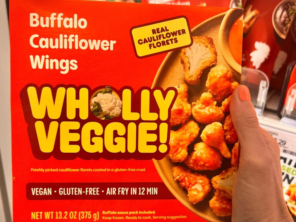 hand holding up a box of wholly veggie buffalo cauliflower wings