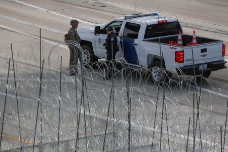 A U.S. Marine interacts with Customs and Border Protection officer at the U.S. Mexico border as the military works to harden the border for the arrival of a caravan of migrants at the San Ysidro border crossing in San Diego, California, U.S., November 13, 2018. REUTERS/Mike Blake