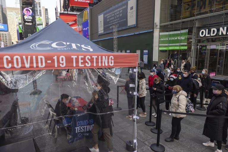 Varias personas hacen fila para un test de COVID-19 en un centro móvil en Times Square