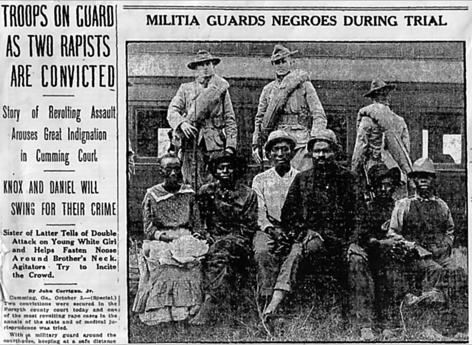 Newspaper clipping with photo of six Black people sitting in front of what appears to be a train with several white people in uniform behind them. Newspaper headline reads: Militia guards negroes during trial