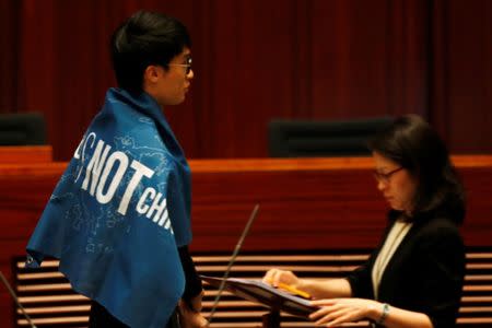 Newly-elected lawmaker Baggio Leung wears a banner "Hong Kong is not China" while taking oath at the Legislative Council in Hong Kong, China October 12, 2016. REUTERS/Bobby Yip