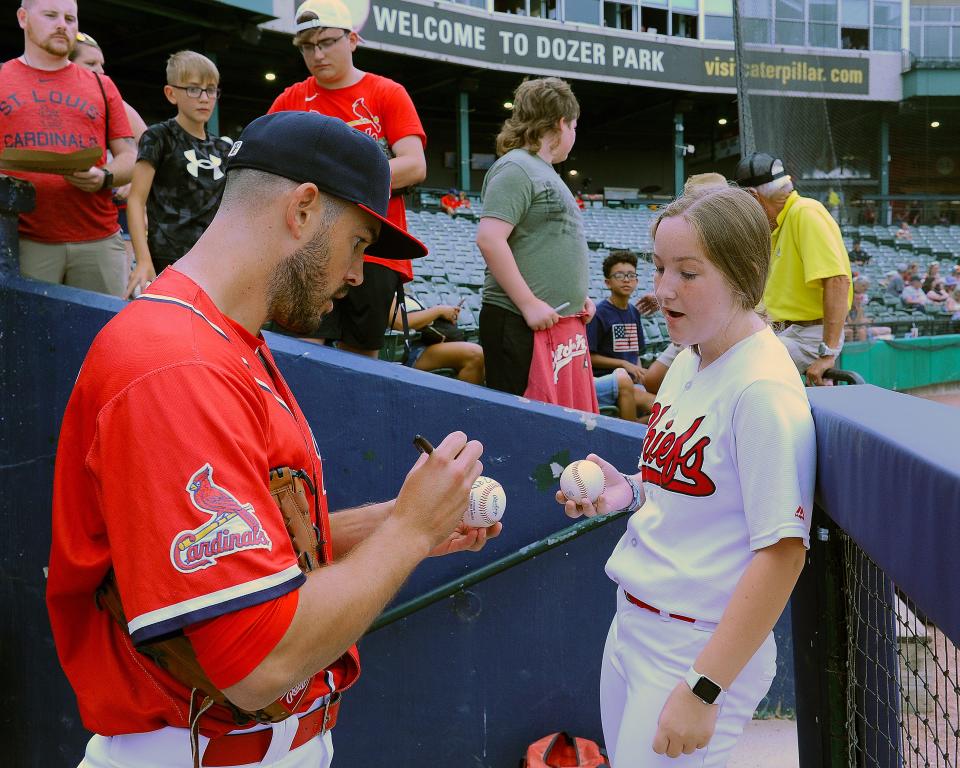 Cardinals reliever Drew VerHagen, in the Peoria Chiefs dugout last week on a rehab assignment, signs a baseball for Chiefs ball girl Elsa Olmstead.