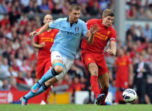 Manchester City's Bosnian forward Edin Dzeko (L) and Liverpool's English midfielder Steven Gerrard compete during an English Premier League football match between Liverpool and Manchester City at Anfield in Liverpool, northwest England. The match ended in a 2-2 draw