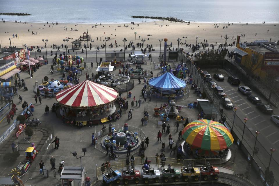 In this Saturday, March 30 2013 photo the beach and visitors to Deno's Famous Wonder Wheel Amusement Park in New York's Coney Island are seen from the park's famous ride. Despite making the traditional Palm Sunday opening, many of the seasonal businesses at Coney Island are still reeling from the aftermath of Superstorm Sandy. (AP Photo/Mary Altaffer)