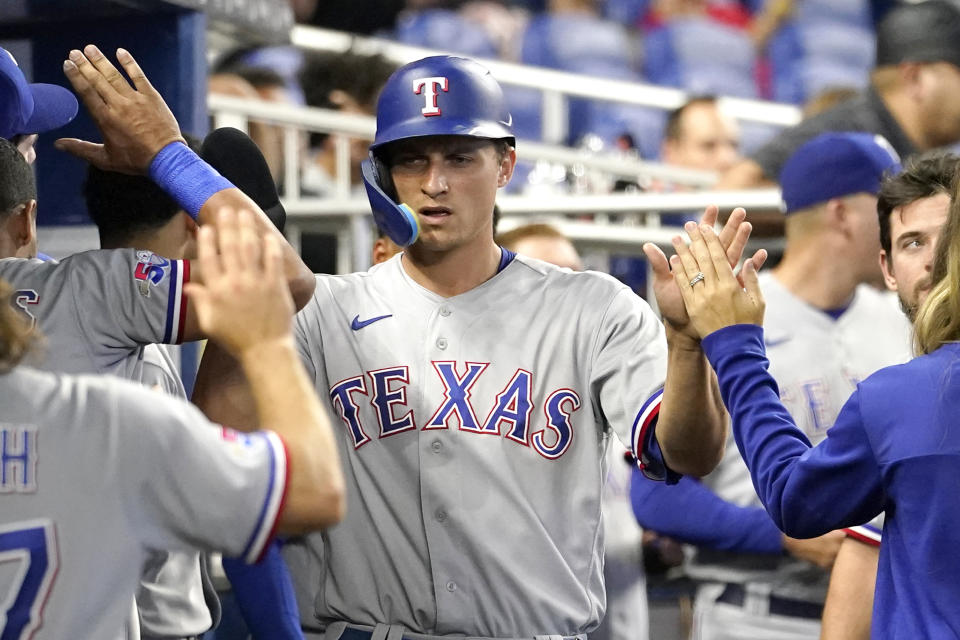 Corey Seager de los Rangers de Texas es felicitado tras anotar con las bases llenas en la octava entrada del encuentro ante los Marlins de Miami el lunes 12 de septiembre del 2022. (AP Foto/Lynne Sladky)