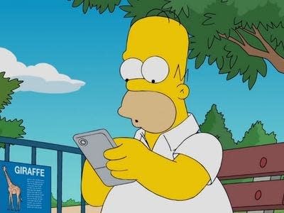Homer Simpsons sitting on a bench and holding a smartphone