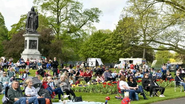 A park full of people sitting in deckchairs 