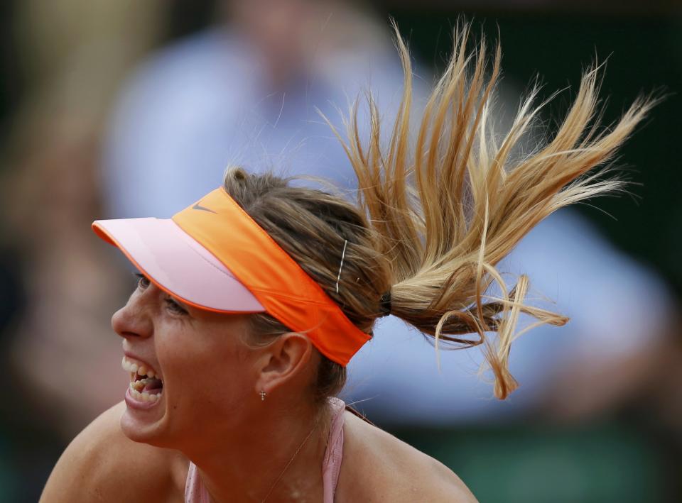 Maria Sharapova of Russia serves to Garbine Muguruza of Spain during their women's quarter-final match at the French Open tennis tournament at the Roland Garros stadium in Paris