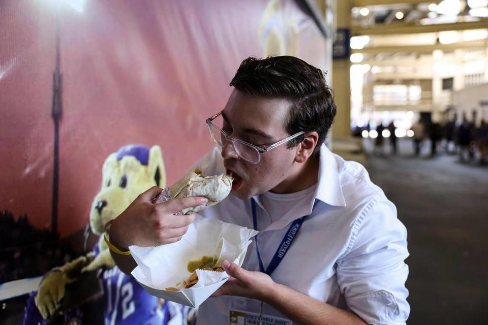 Lexington Herald-Leader reporter Cameron Drummond tries a steak burrito from Nathan’s Taqueria before Kentucky’s football home opener against Ball State at Kroger Field on Saturday. Drummond appreciated the spice level of the accompanying salsa verde, as well as the ability to use tortilla chips to eat the fallen remnants of his burrito.