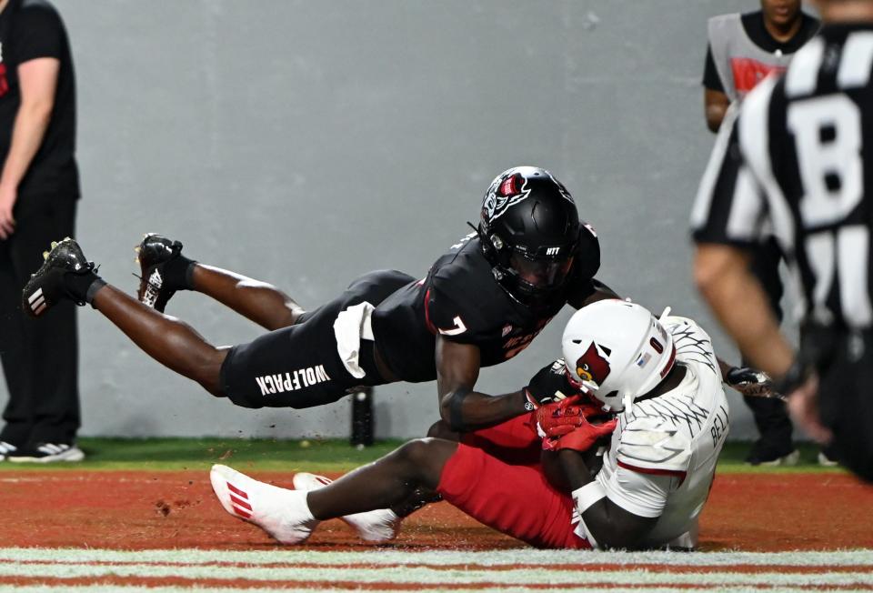 Sep 29, 2023; Raleigh, North Carolina, USA; Louisville Cardinals receiver Chris Bell (0) catches a touchdown in front of North Carolina State Wolfpack cornerback Shyheim Battle (7) during the second half at Carter-Finley Stadium. The Louisville Cardinals won 13-10. Mandatory Credit: Rob Kinnan-USA TODAY Sports